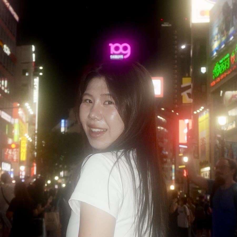 Phoebe Pan smiling on a city street at night