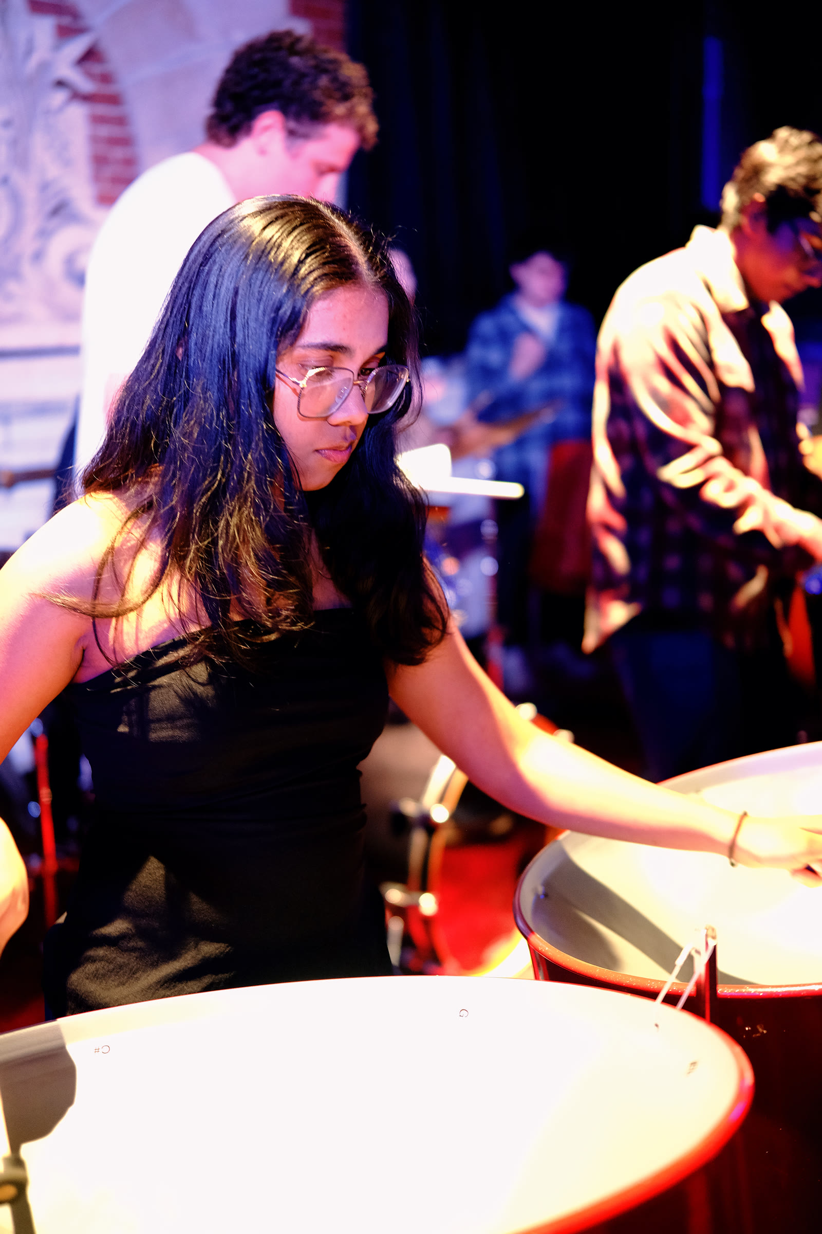 An ensemble member concentrating on her steelpan part during rehearsal.