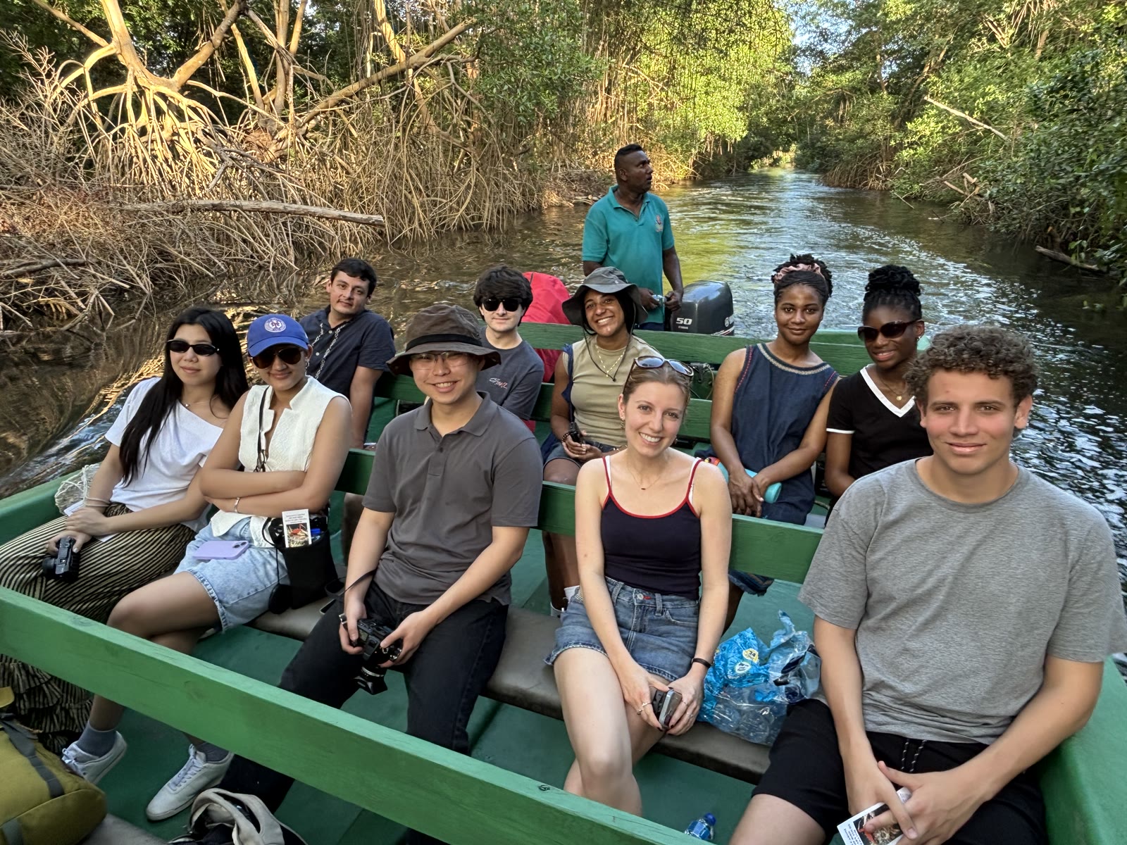 Ensemble members riding in a boat through the mangroves of Caroni Swamp.
