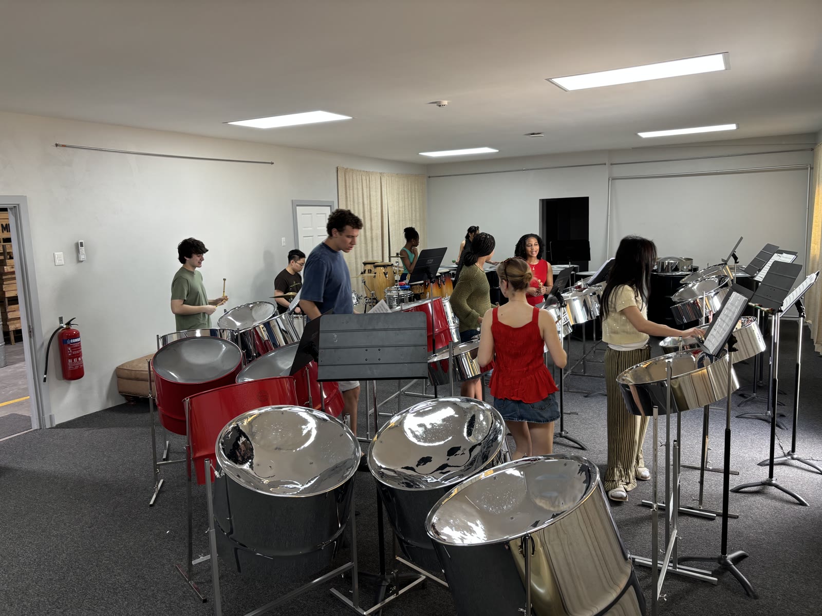Ensemble members inside the MITTCO practice room surrounded by steelpans.